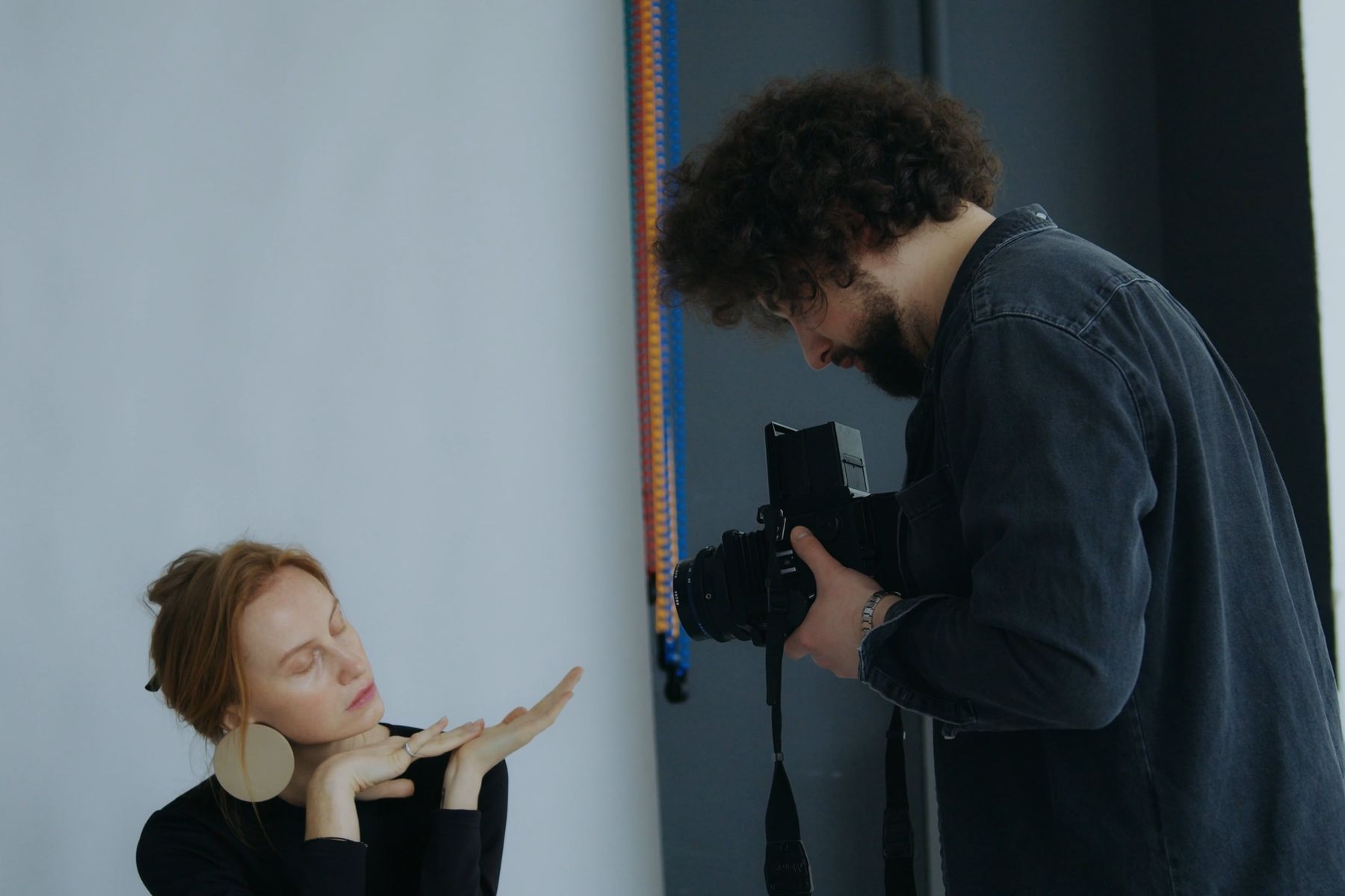 Mara Voss photographing a portrait sitter in a studio.